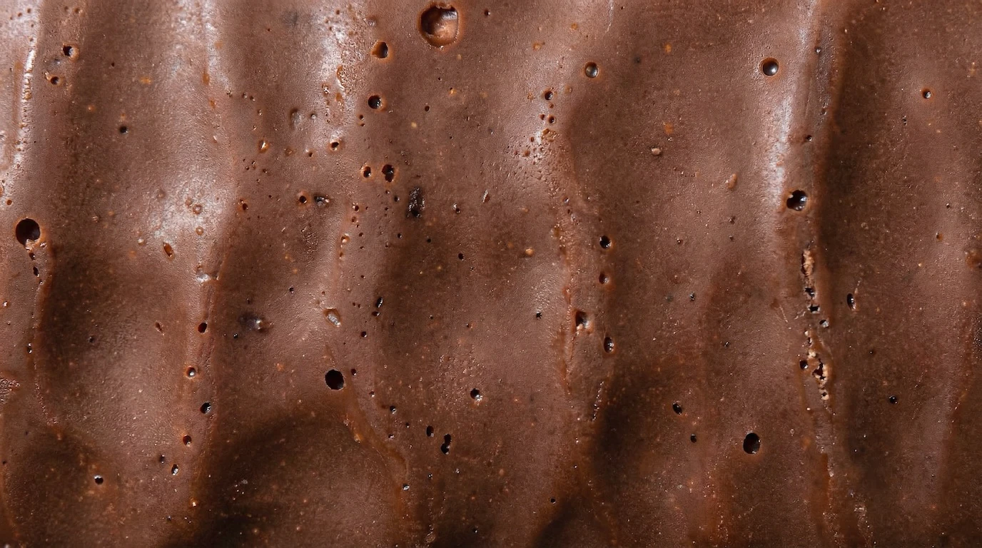 Macro chocolate texture with vertical ridges and air bubbles